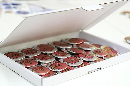 Versandkarton mit Metallicbuttons gefüllt