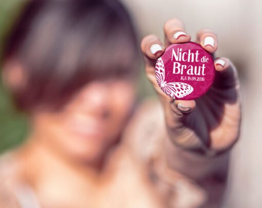 Frau mit JGA Button Nr. 8 in der Hand