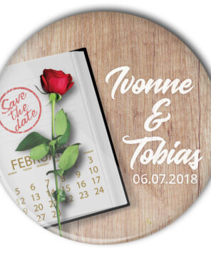 Hochzeitsbutton 46 mit Terminplaner und roter Rose auf Tisch: individualisiert