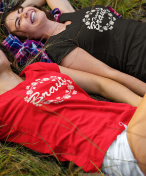 2 Frauen liegen zum JGA lachend im Gras und tragen JGA-Shirts T73