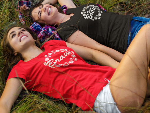 2 Frauen liegen zum JGA lachend im Gras und tragen JGA-Shirts T73